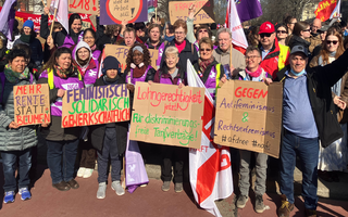Ein Gruppenbild von Frauen beim 8. März mit Schildern. 